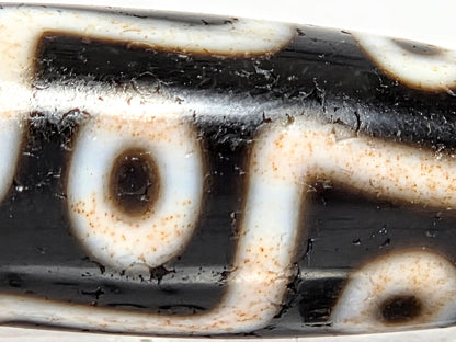 At-070626-9EBS macro, cinnabar bloodspot micro-dots in cream connector band zones, warm-toned motif lines, unretouched