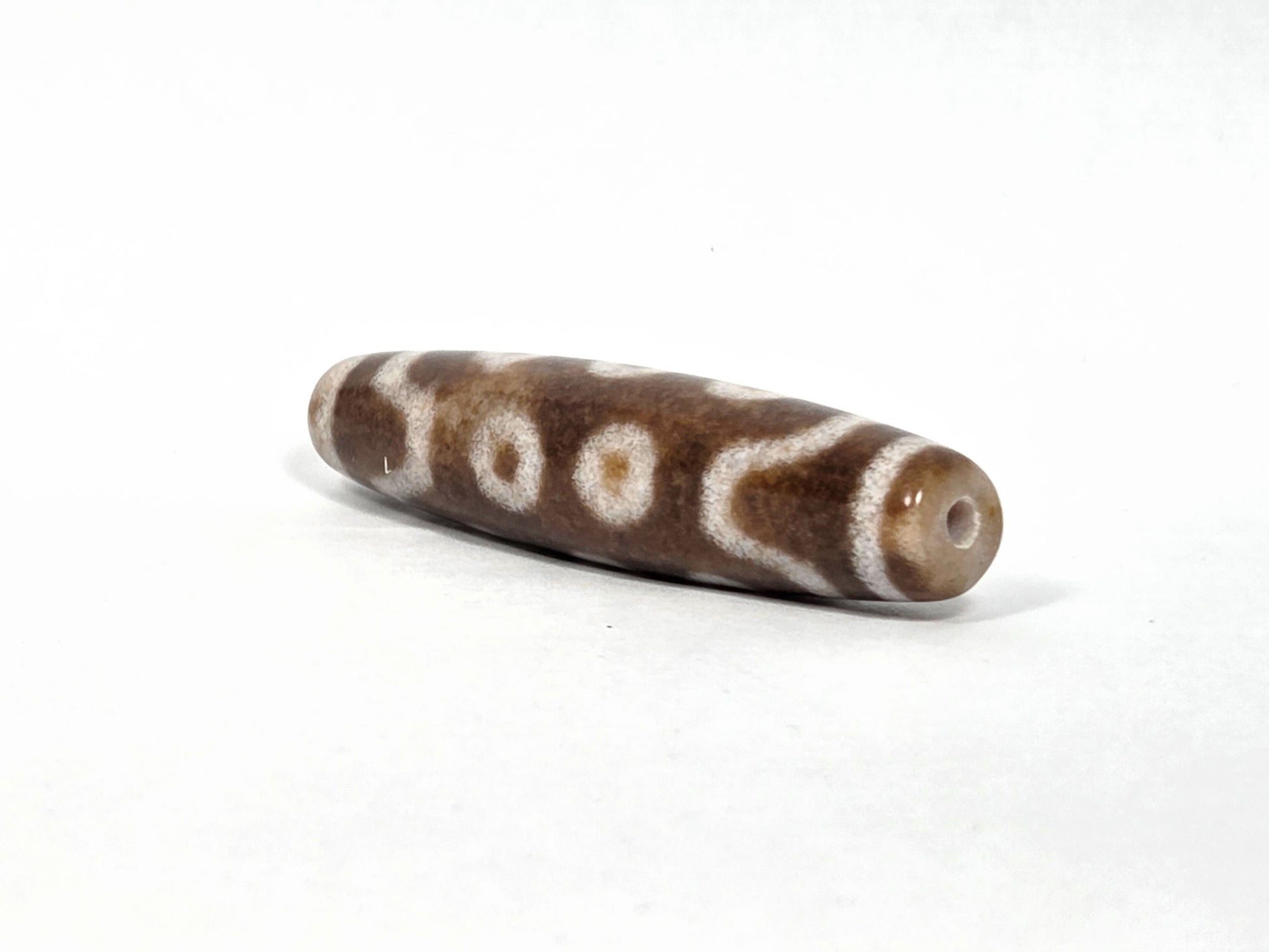 N-083126-10E new ten eye dzi bead drill end view two warm brown fusiform taper unretouched