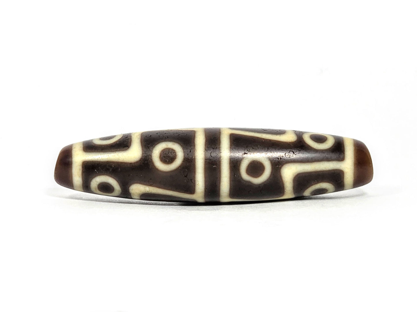 Ac-070826-12E ancient twelve eye dzi bead 60.3×15.1mm chocolate-brown agate front face showing full motif unretouched