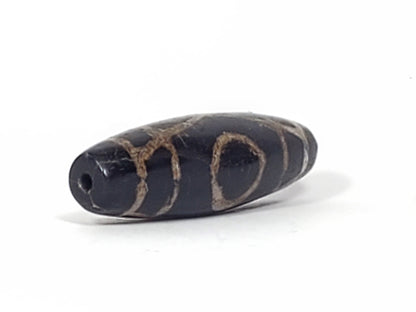 Ac-070926-TWE ancient two eye dzi opposite drill end angled view pitch-black agate heavy calcification unretouched