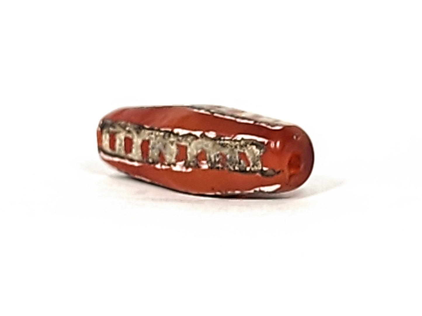 Ac-010825-4RT angled view, tapered end with drill hole, terracotta-red carnelian, rail band visible, unretouched