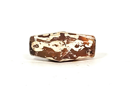 Ac-032425-LK face D, heaviest mineral deposit coverage, cream-white over dark ground, warm end cap zone, unretouched