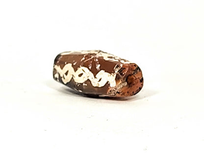 Ac-032425-LK angled end view, drill hole visible, warm orange-brown carnelian end cap, links band, unretouched
