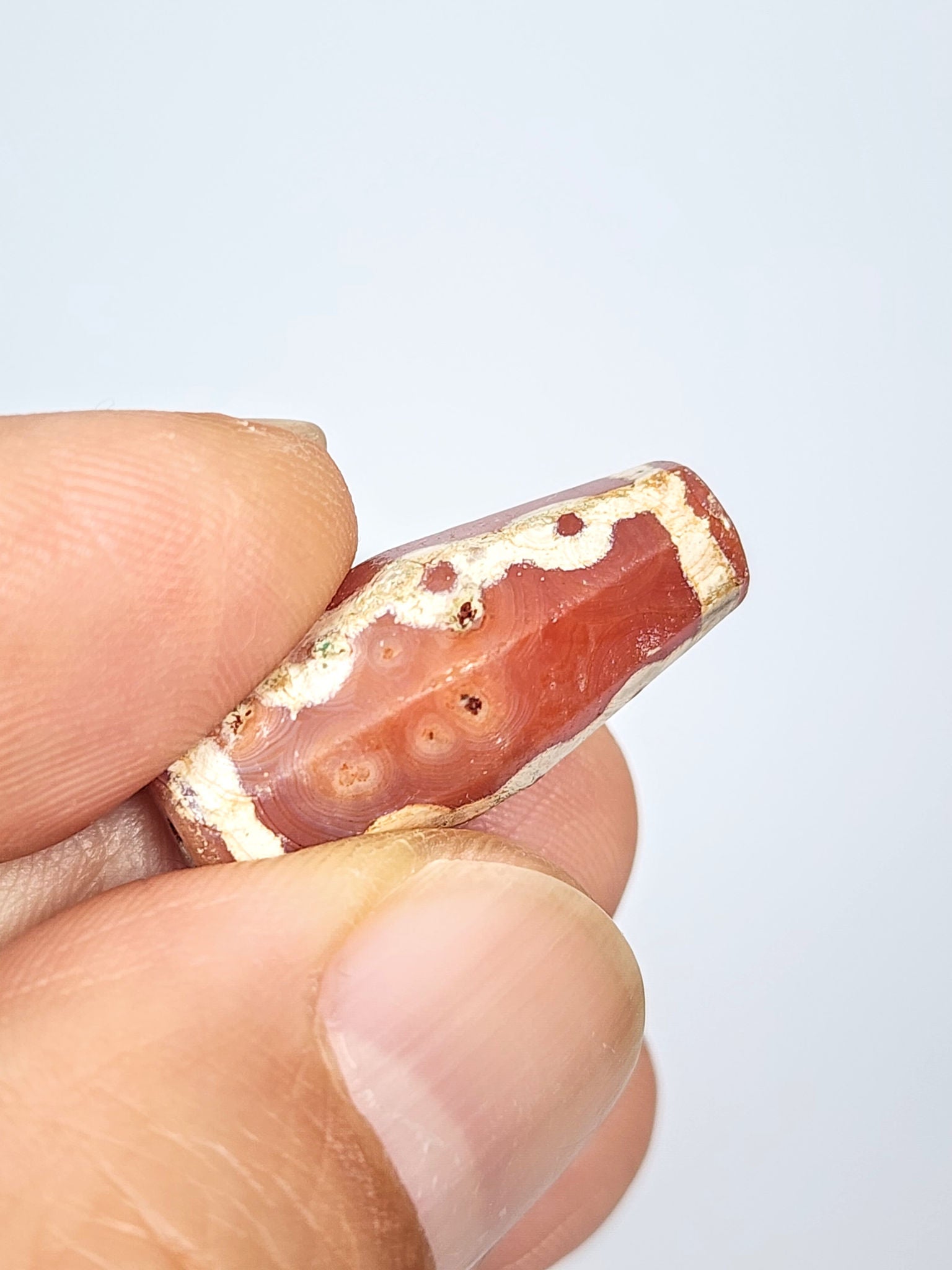 Ac-050725-LKBS bloodspot macro, 4–5 sub-surface cinnabar dots in carnelian zone, 2 pinholes visible, unretouched