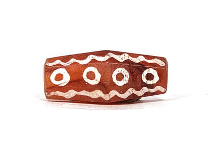 Ac-010825-16EW face C, 4 ring eyes, sinuous wave borders, sharp octagonal ridge visible, terracotta-red, unretouched
