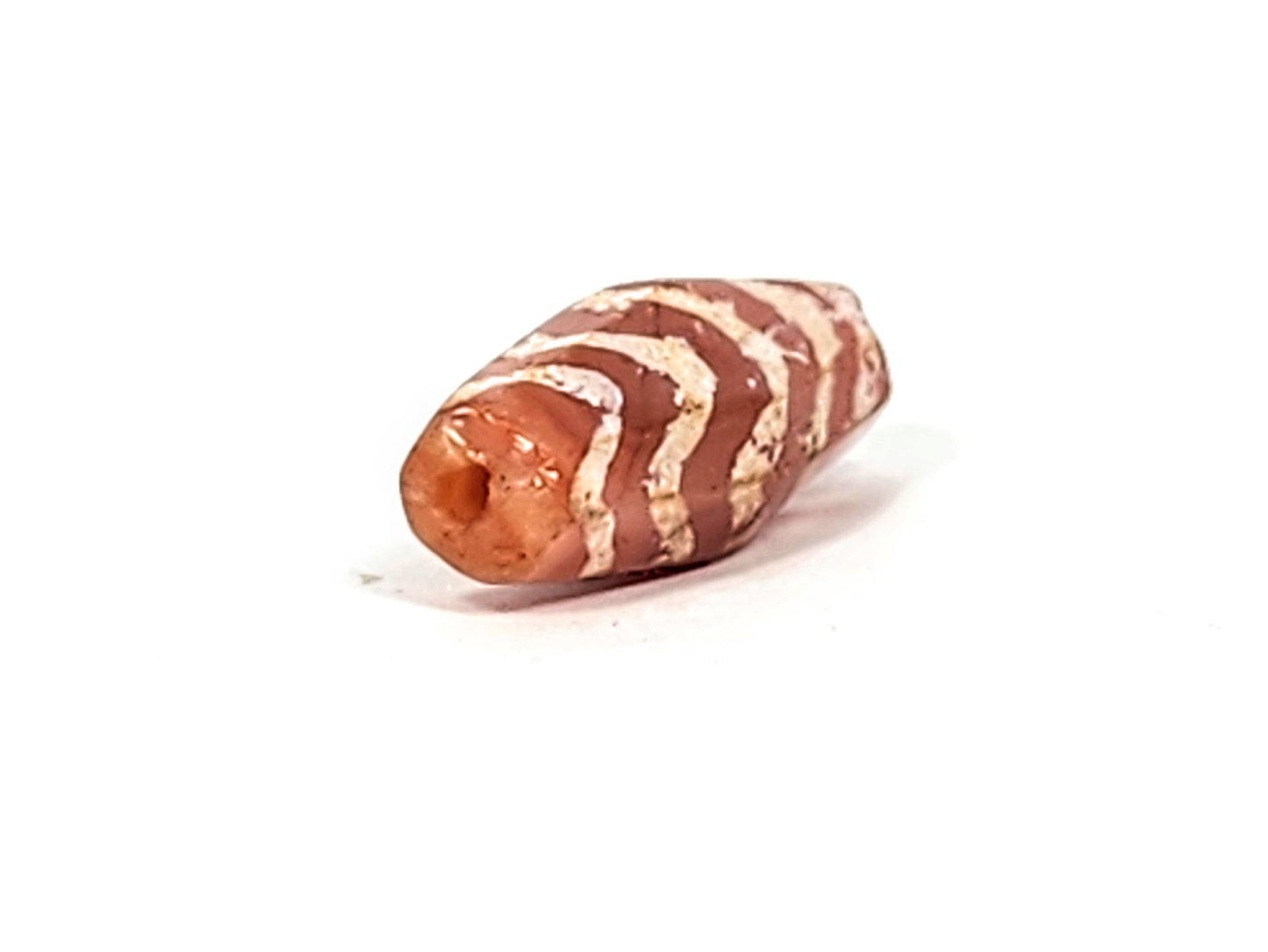 Ac-030525-5TS carnelian dzi End B, flatter terminus, drill hole and weathered motif lines visible, unretouched
