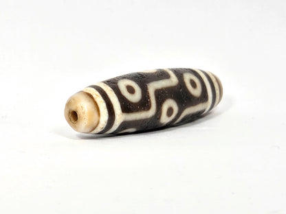Ac-070926-9E ancient nine eye dzi angled view left drill end cream agate body full profile unretouched
