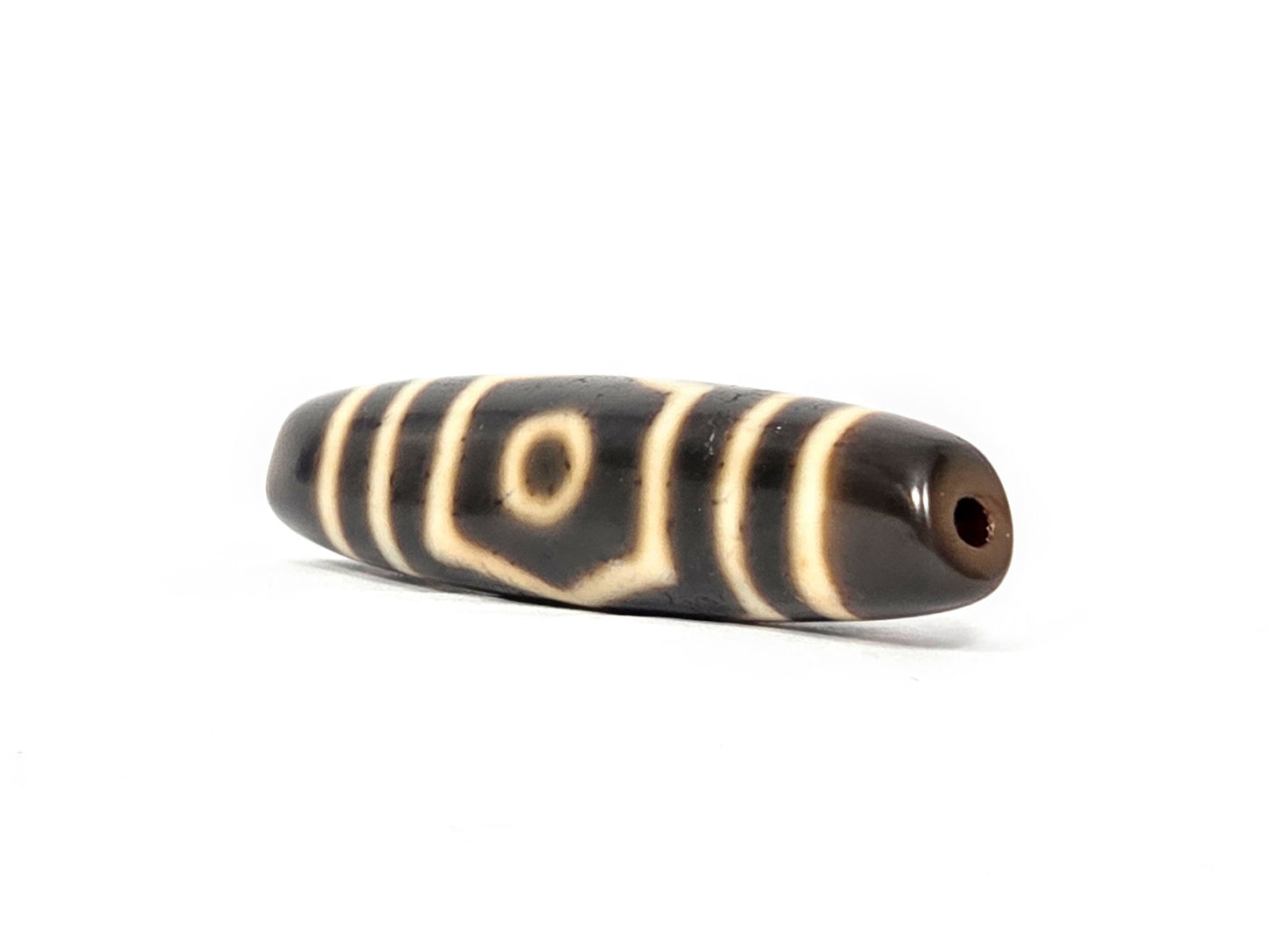 Ac-070926-THE ancient three eye dzi angled view right drill end warm reddish-brown end cap one eye visible unretouched