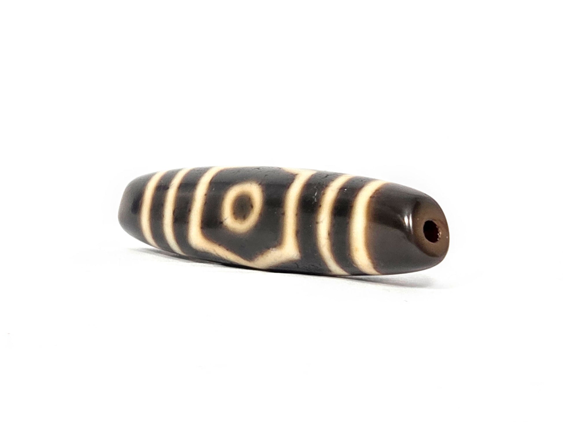Ac-070926-THE ancient three eye dzi angled view right drill end warm reddish-brown end cap one eye visible unretouched