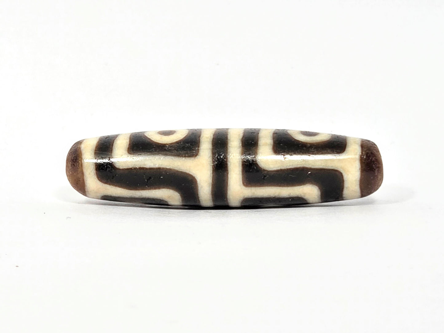 Ac-080425-4E Face B, interlocking S-curve key-fret meander, cream-white on dark warm brown ground, unretouched
