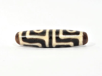 Ac-080425-4E Face B, interlocking S-curve key-fret meander, cream-white on dark warm brown ground, unretouched
