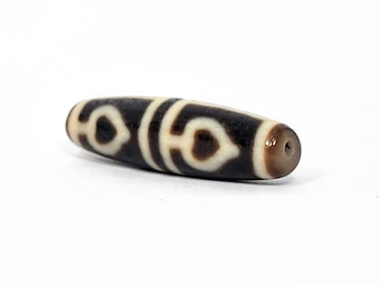 Ac-070625-FLB3 right drill hole end, warm honey-brown end cap, bodhi leaf forms wrapping pitch-black body, unretouched