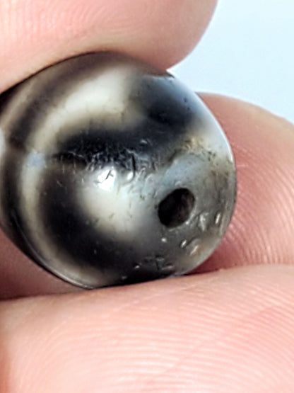 Ac-021724-TT ancient round tiger tooth dzi, macro opposite drill end, surface texture, unretouched