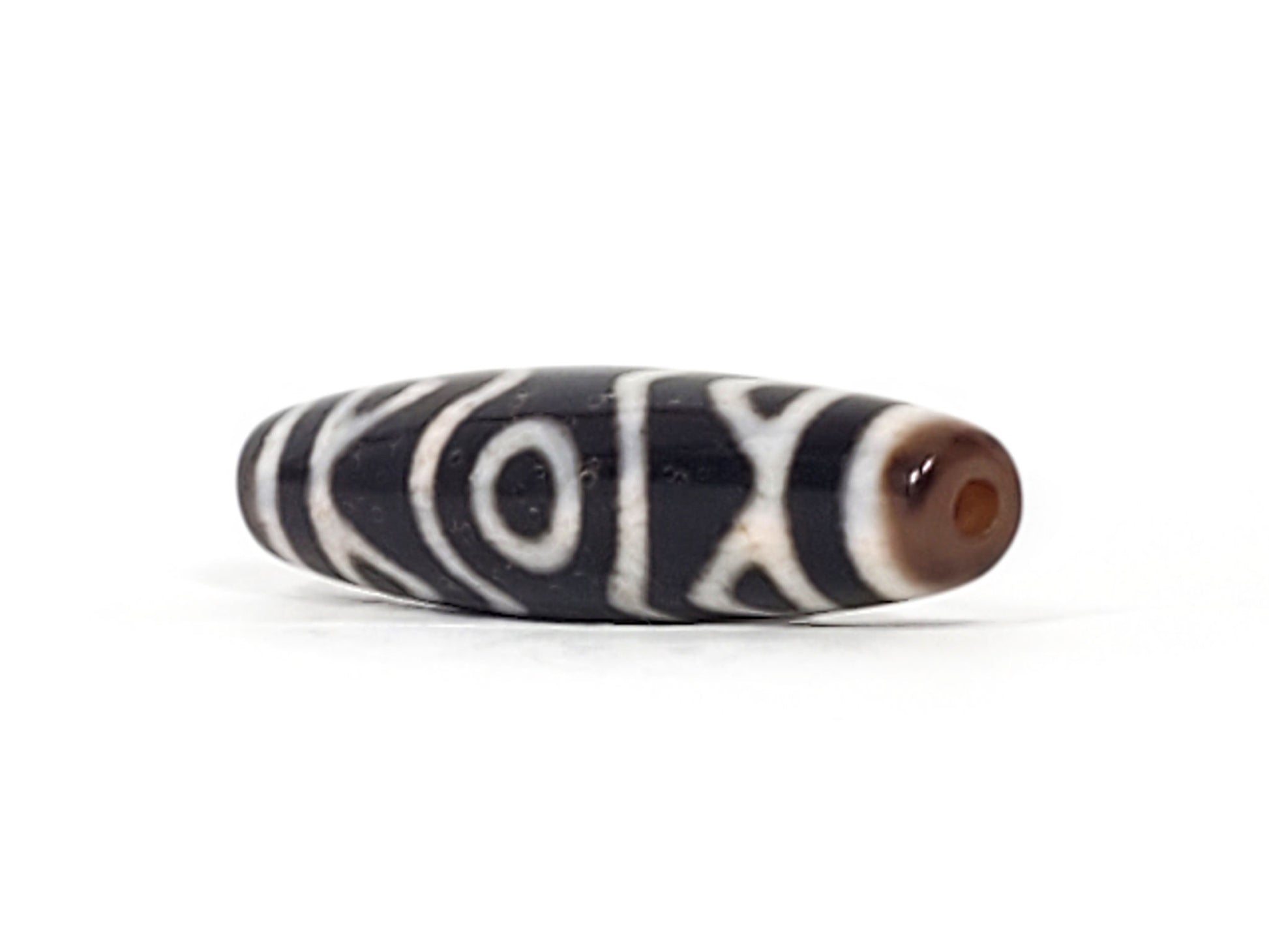 At-070926-3ETTBS antique three eye tiger tooth dzi angled view right drill end warm reddish-brown end cap unretouched