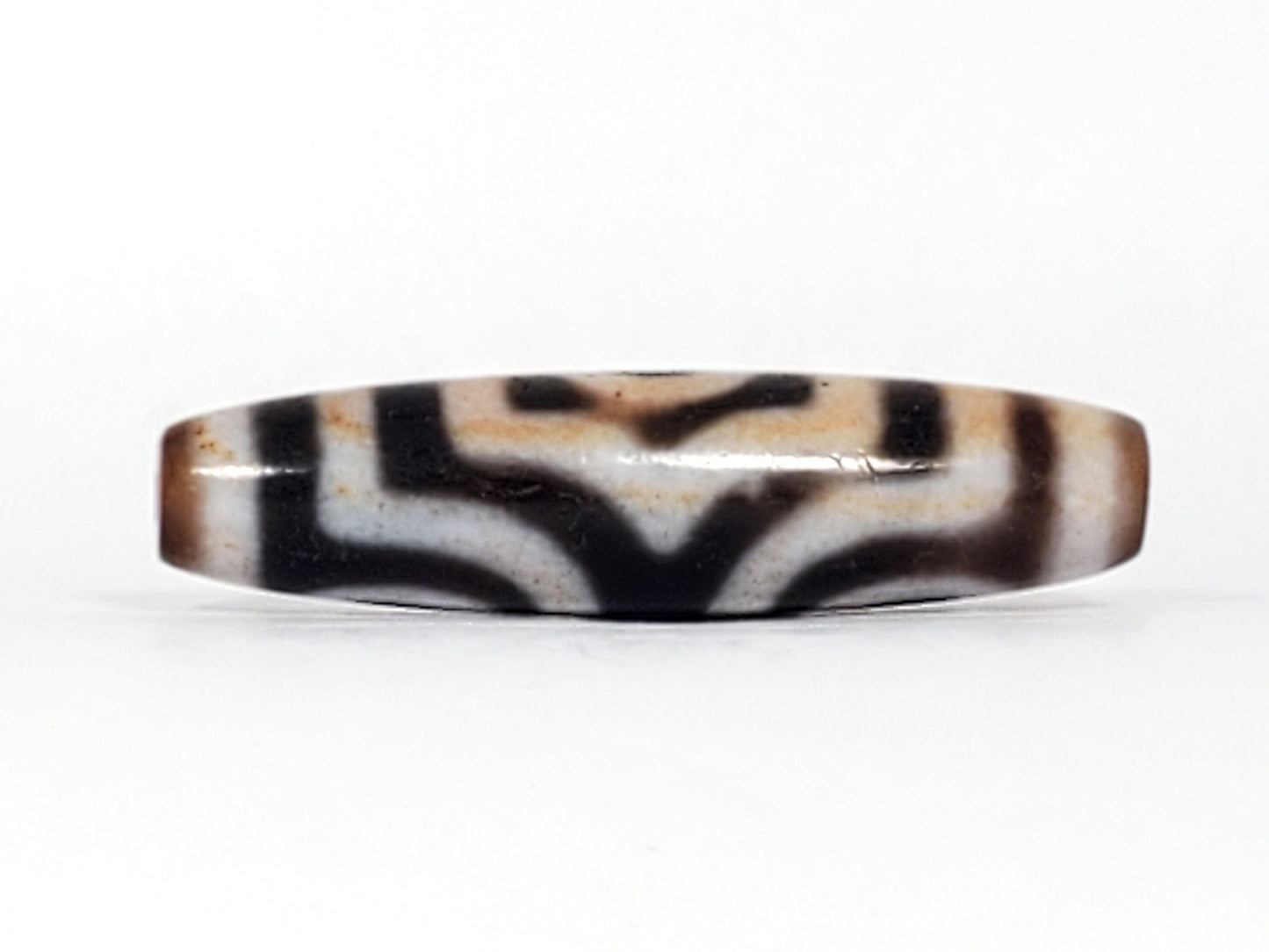 Rotated second face of antique Three Eye Dzi bead — bold white eye circles on deep black agate, 47.8mm, cinnabar bloodspot inclusions throughout