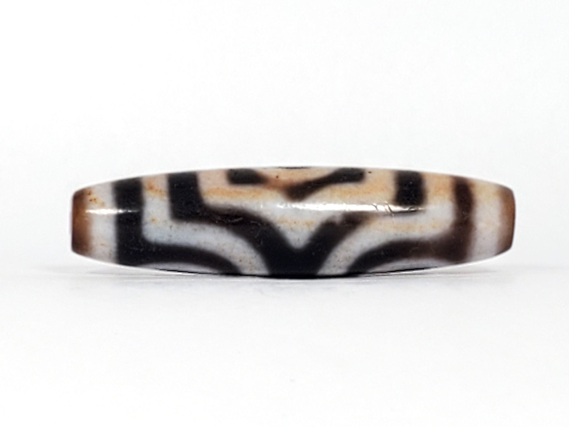 Rotated second face of antique Three Eye Dzi bead — bold white eye circles on deep black agate, 47.8mm, cinnabar bloodspot inclusions throughout