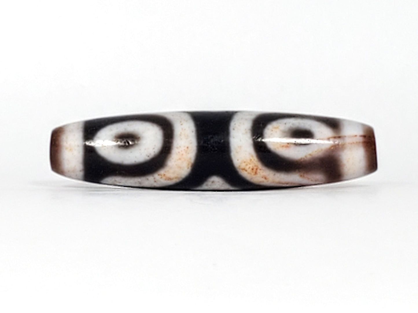 Third angle of antique Three Eye Dzi bead — all three eye circles visible across 47.8mm length, genuine Tibetan amulet, 100–200 years old