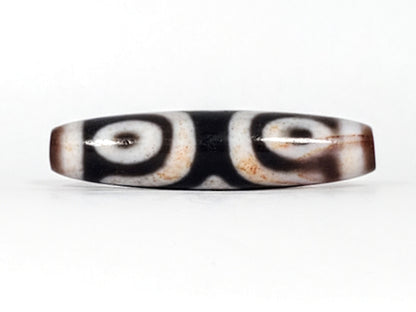 Third angle of antique Three Eye Dzi bead — all three eye circles visible across 47.8mm length, genuine Tibetan amulet, 100–200 years old