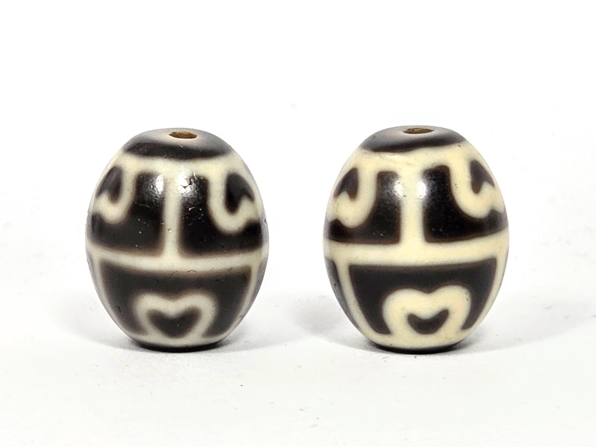 Reverse side of rare round Dzi beads showing the integration of Lotus and Tortoise Shell motifs.