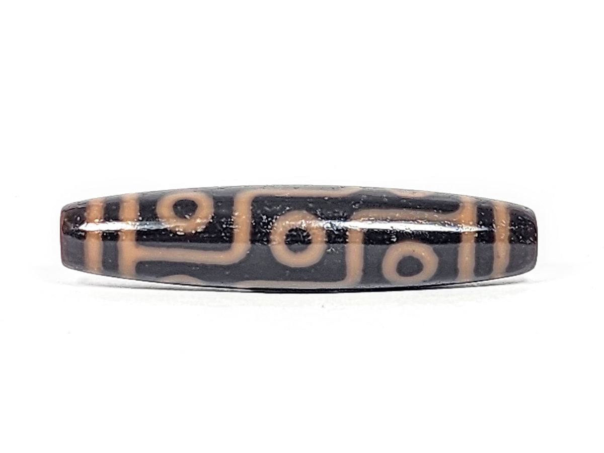Antique nine eye dzi bead At-012325-9E4, front face, nine amber-orange eye rings on deep dark brown agate, full torpedo 59.0mm × 13.2mm, unretouched photography