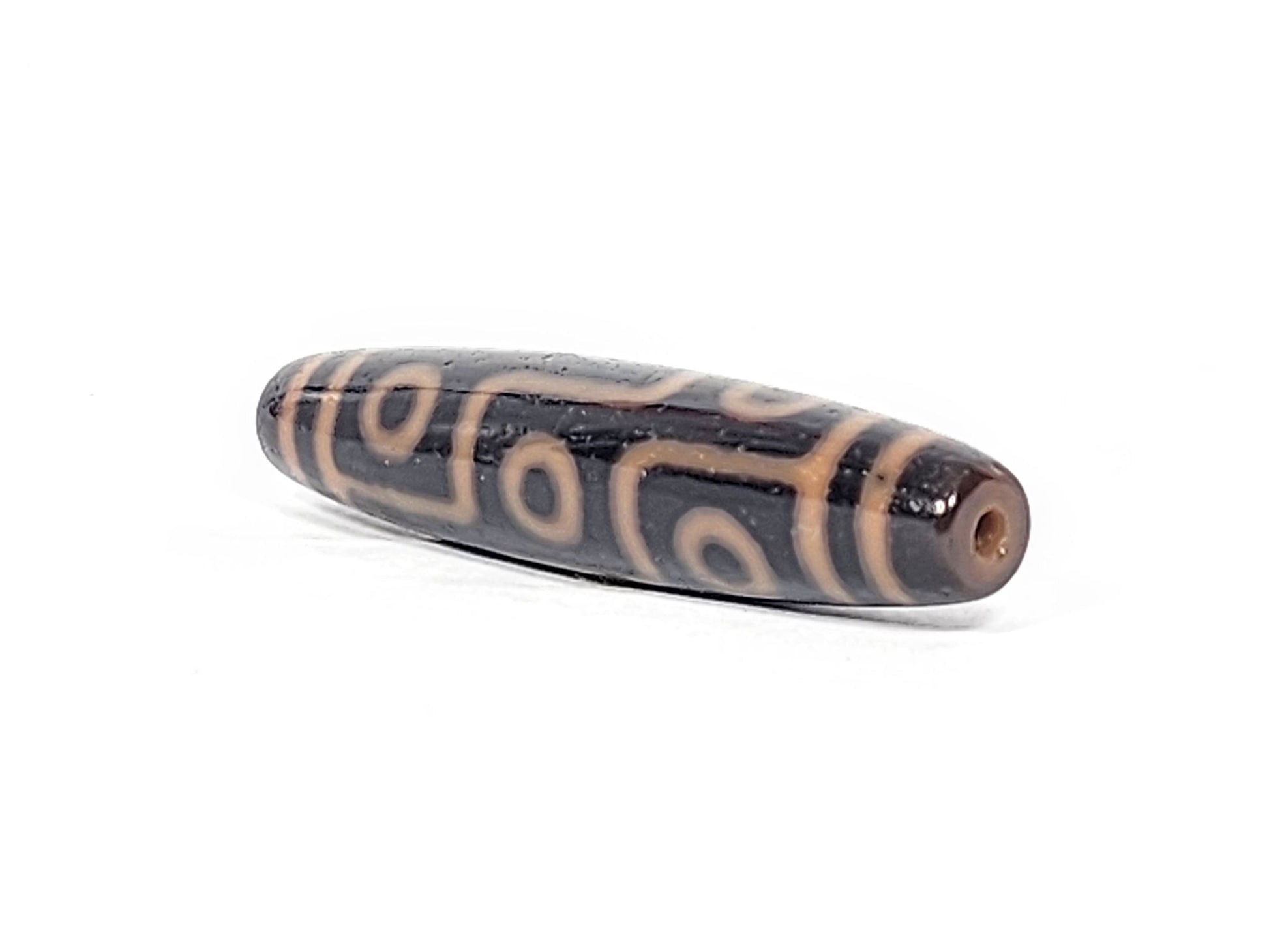 Antique nine eye dzi bead At-012325-9E4, front face, nine amber-orange eye rings on deep dark brown agate, full torpedo 59.0mm × 13.2mm, unretouched photography