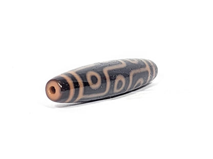 Opposite end cap of antique nine eye dzi At-012325-9E4, deep dark brown agate tip, centred drill hole, amber nine eye motif visible, 59.0mm × 13.2mm, unretouched