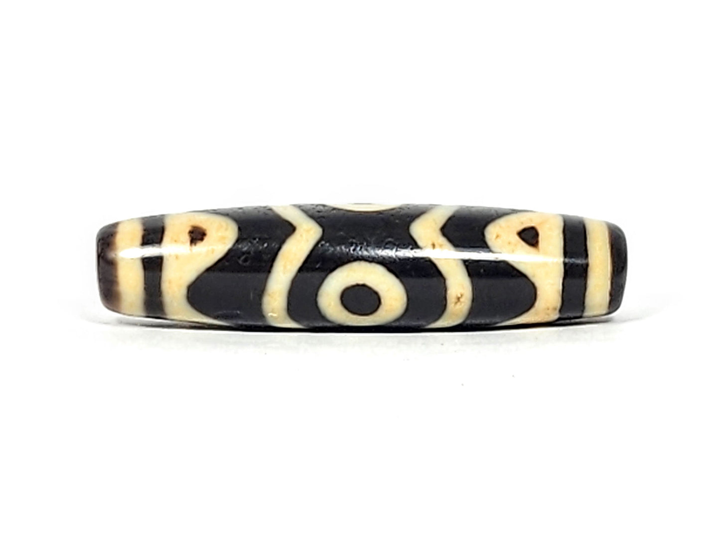 At-061926-3ETT Face C, third closed eye, open tiger tooth arcs, pitch-black ground, unretouched