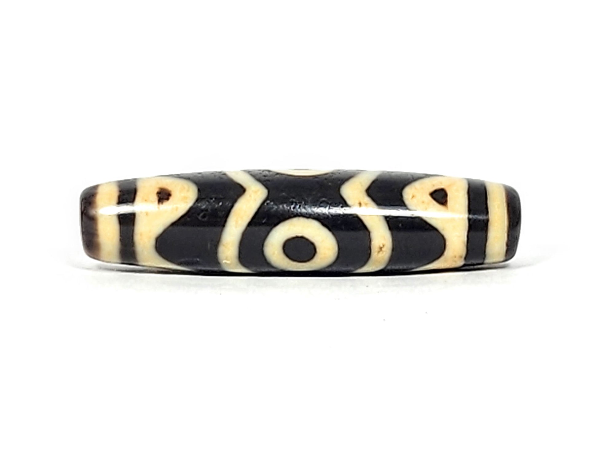 At-061926-3ETT Face C, third closed eye, open tiger tooth arcs, pitch-black ground, unretouched
