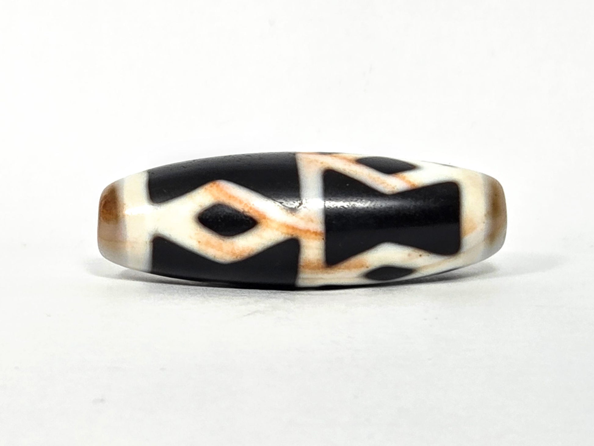 At-062126-6DE dzi bead, close side profile, golden-brown accent banding visible, unretouched