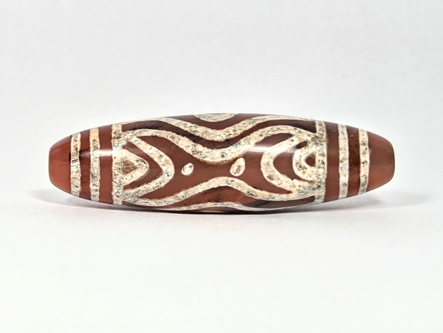 At-061426-2ETTSt carnelian dzi, Face D, hourglass-bowtie motif + star dots, cream-white etching, unretouched