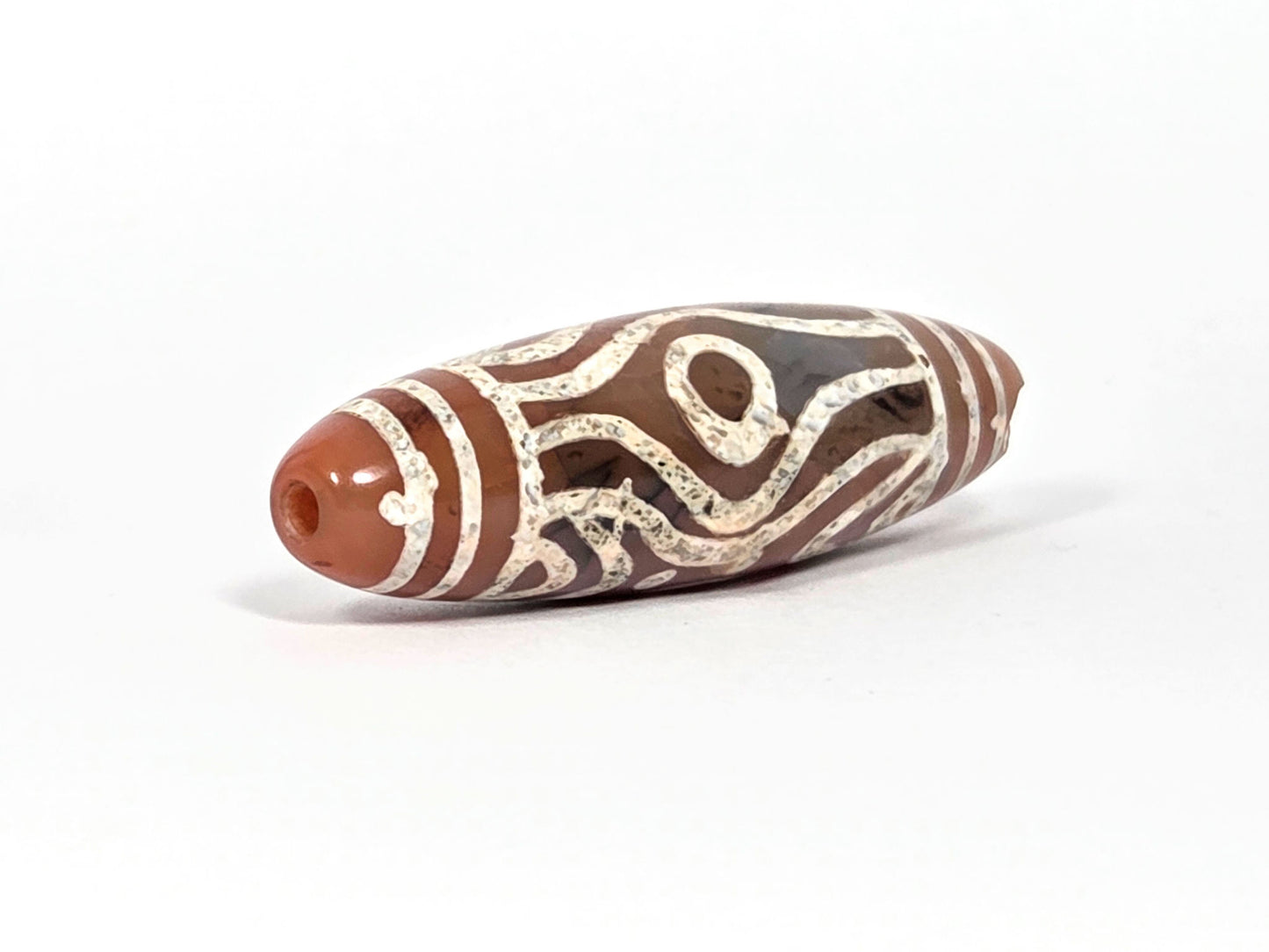 At-061426-2ETTSt carnelian dzi, intact left end cap, terracotta-red tip, clean drill hole, hairline disclosed, unretouched