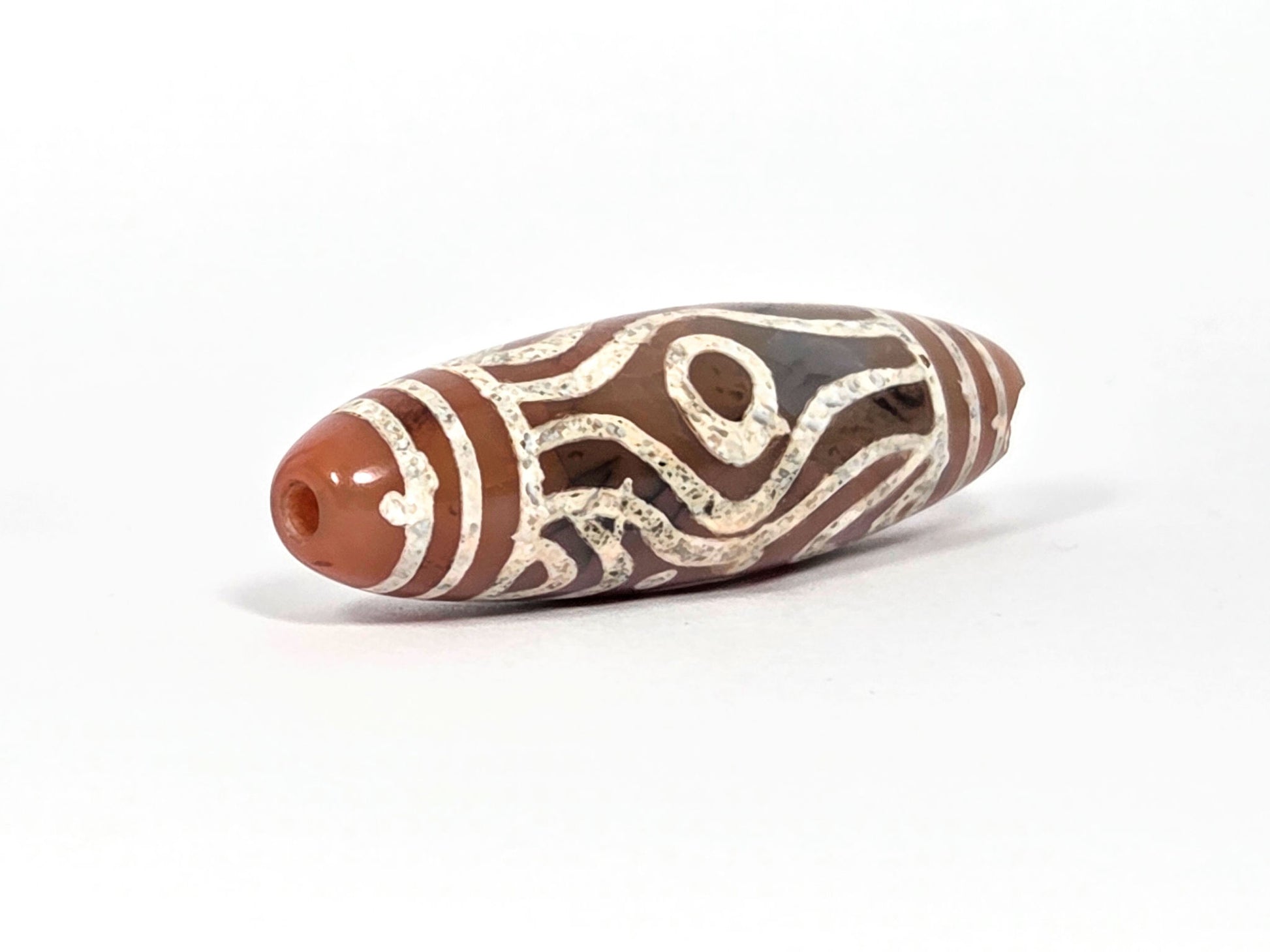 At-061426-2ETTSt carnelian dzi, intact left end cap, terracotta-red tip, clean drill hole, hairline disclosed, unretouched