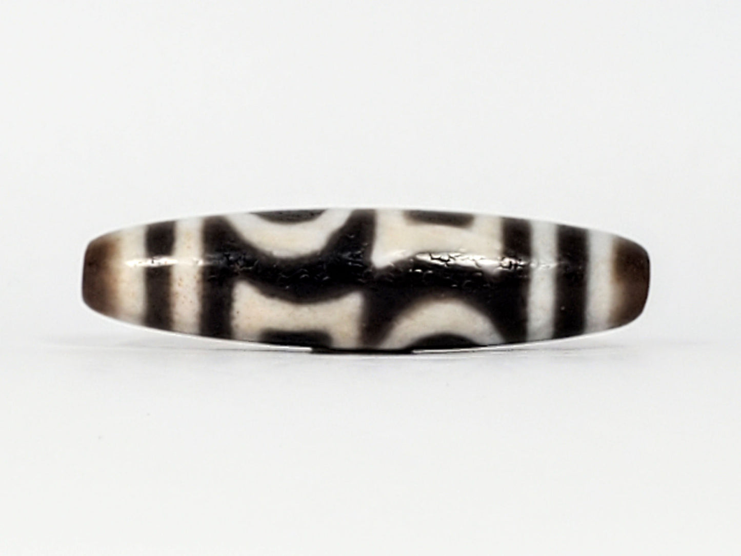 Second angle of antique Double Heaven & Earth Dzi — eye and Earth forms, cream on warm grey agate