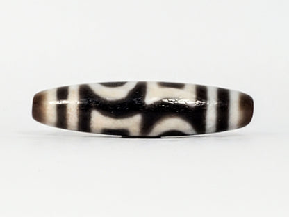 Second angle of antique Double Heaven & Earth Dzi — eye and Earth forms, cream on warm grey agate