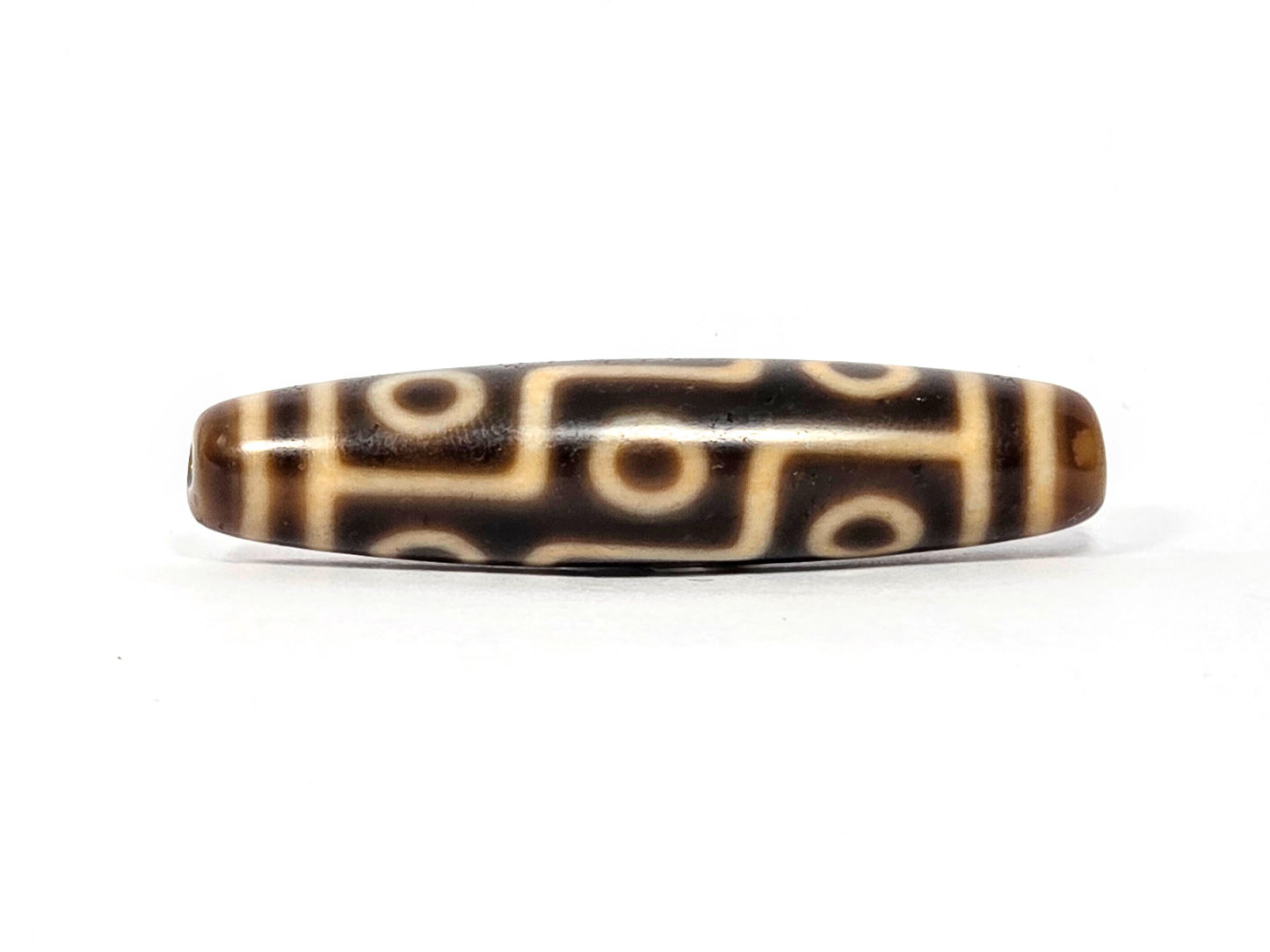 Antique Nine Eye dzi bead face B showing connected eye network with warm tonal brown agate ground, At-083025-9E3