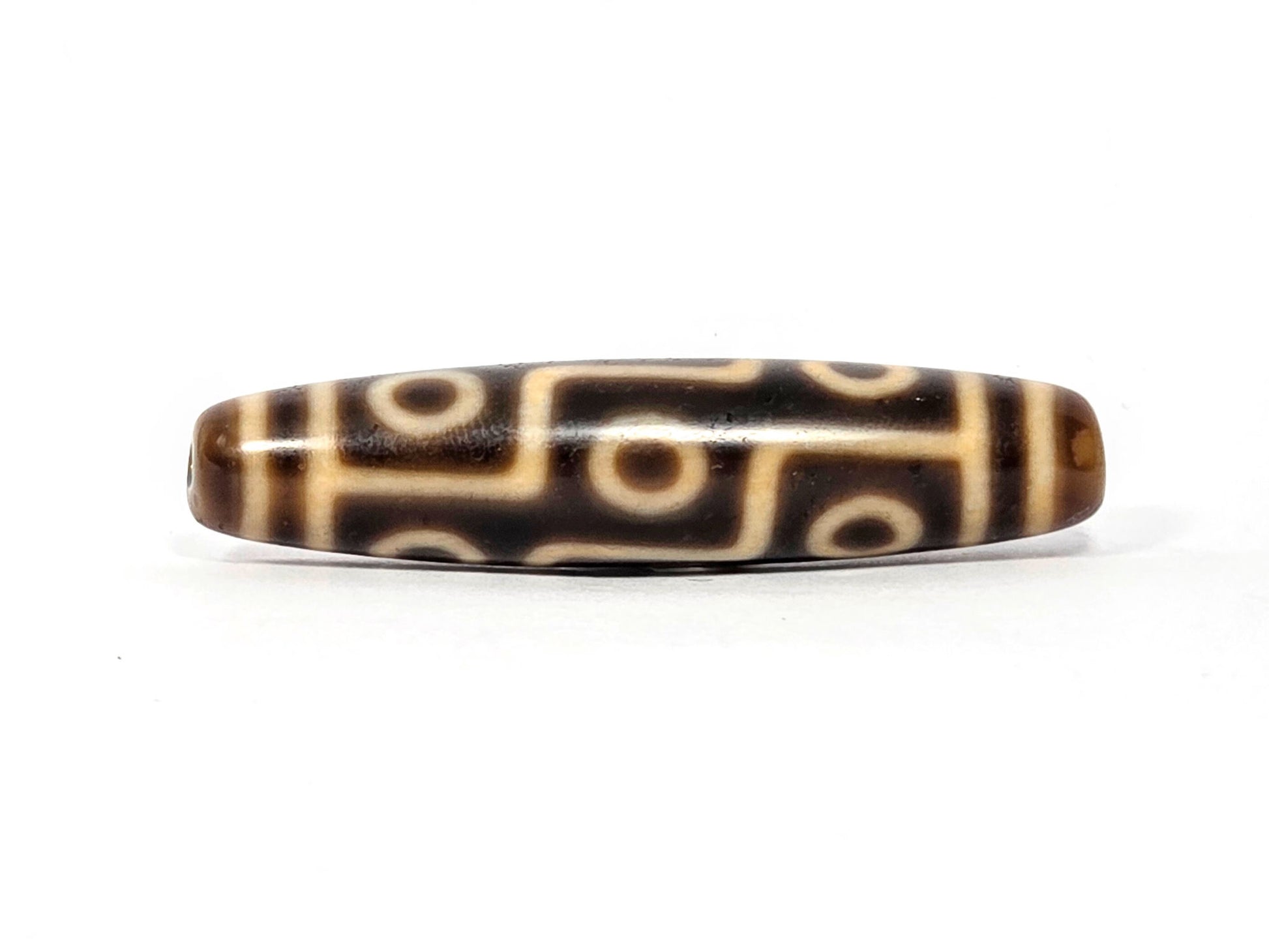 Antique Nine Eye dzi bead face B showing connected eye network with warm tonal brown agate ground, At-083025-9E3