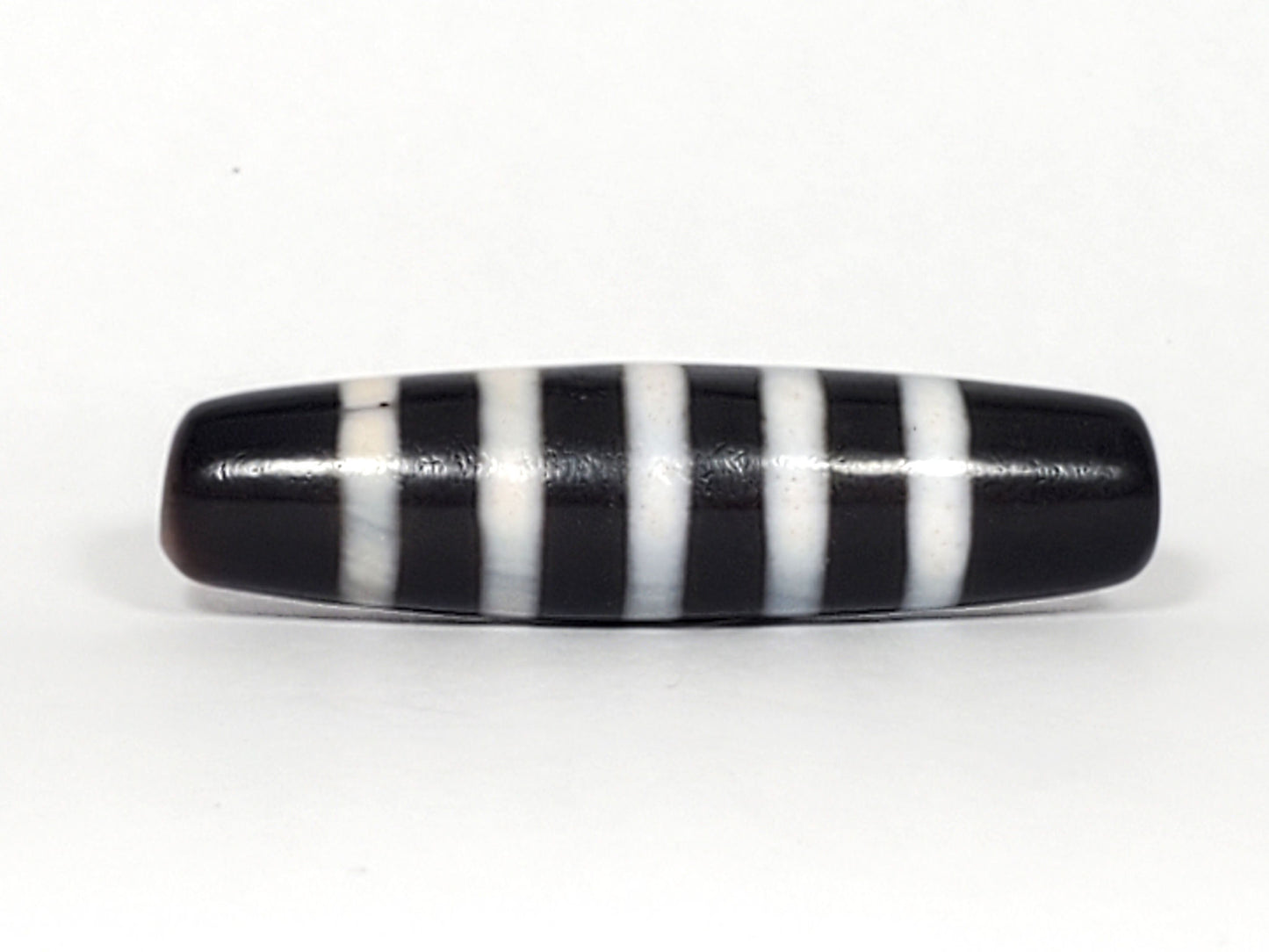 At-110223-9SBS, Face B lower profile, pitch-black fusiform body, nine pale stripe bands, micro-pitting visible, unretouched