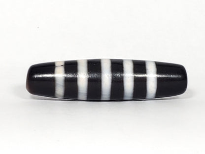 At-110223-9SBS, Face B lower profile, pitch-black fusiform body, nine pale stripe bands, micro-pitting visible, unretouched