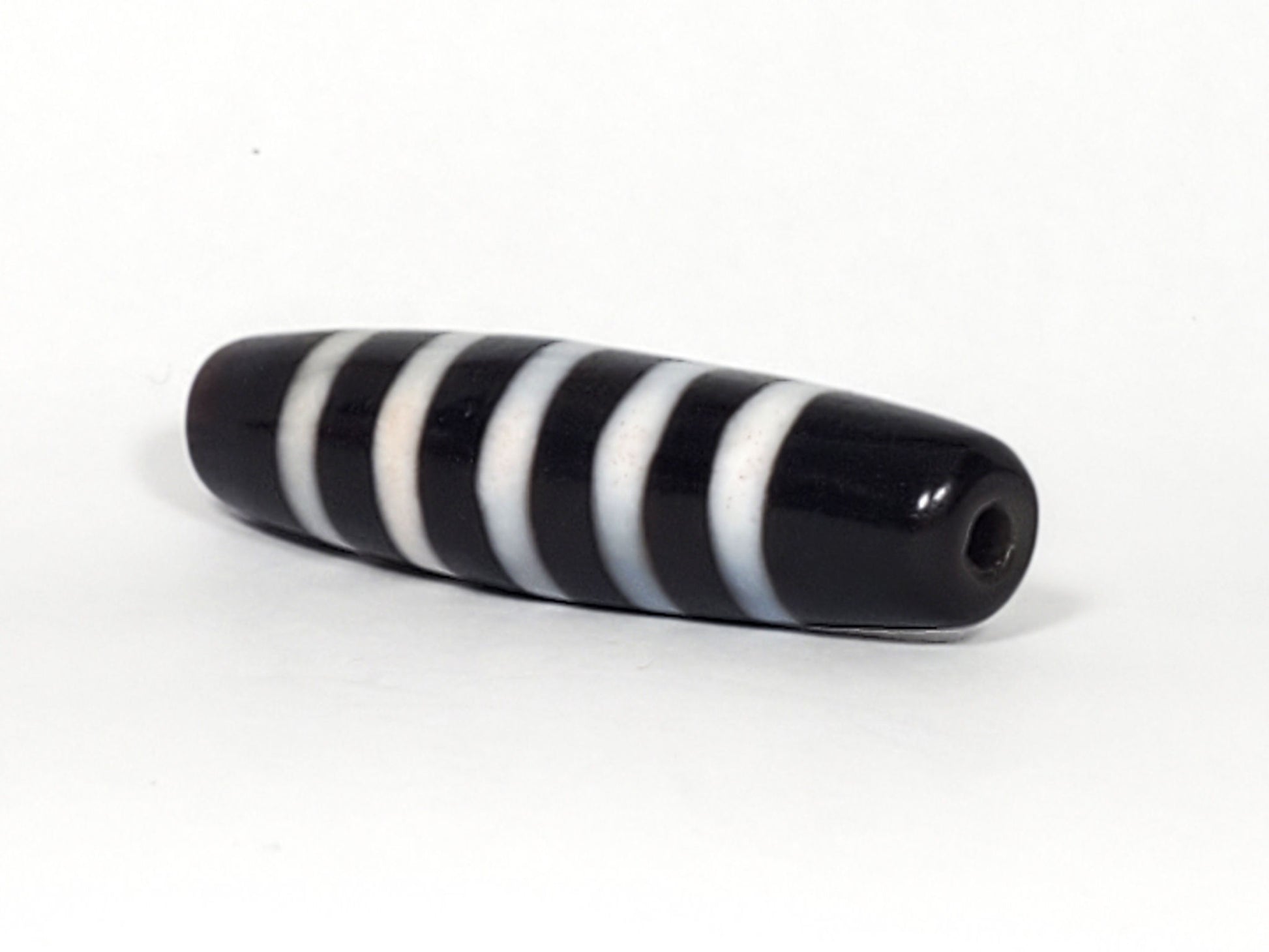 At-110223-9SBS, right tip drill hole, pitch-black end cap, five stripe bands visible wrapping tip, unretouched