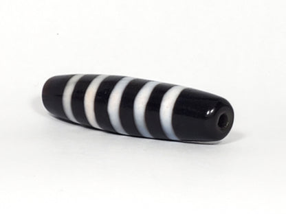 At-110223-9SBS, right tip drill hole, pitch-black end cap, five stripe bands visible wrapping tip, unretouched