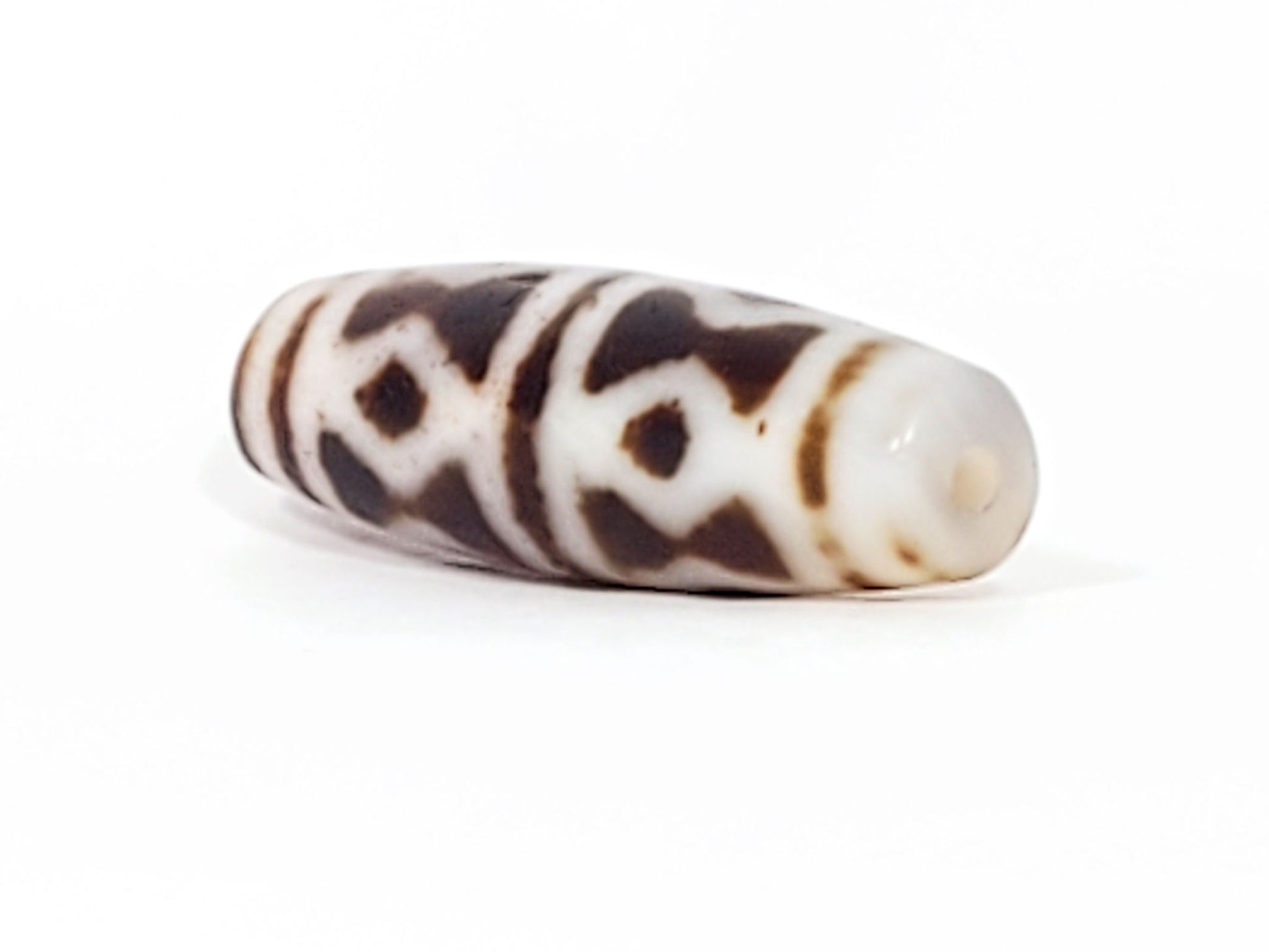 At-082524-DS antique diamond spear agate dzi 40.5x13.1mm angled view gradual taper end cream-white drill hole unretouched