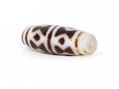 At-082524-DS antique diamond spear agate dzi 40.5x13.1mm angled view gradual taper end cream-white drill hole unretouched