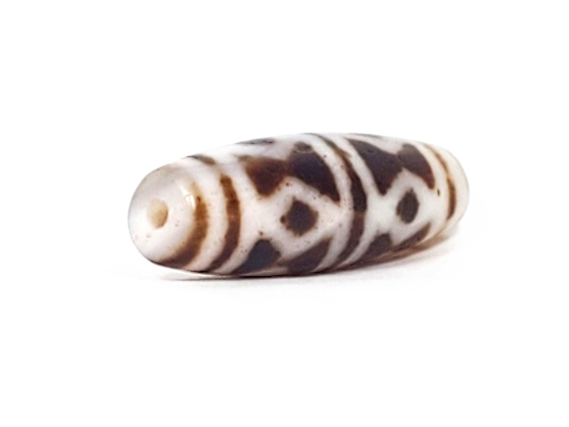 At-082524-DS antique diamond spear agate dzi 40.5x13.1mm angled view abrupt taper end cream-white drill hole unretouched