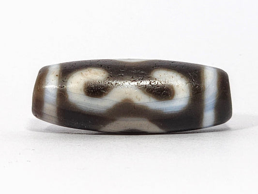Antique Double Bat Two Eye dzi At-060725-DB2E2, Face A, broad cream double bat wing forms on graphite grey-brown agate, bat pupils visible, 31.5mm × 11.6mm, unretouched