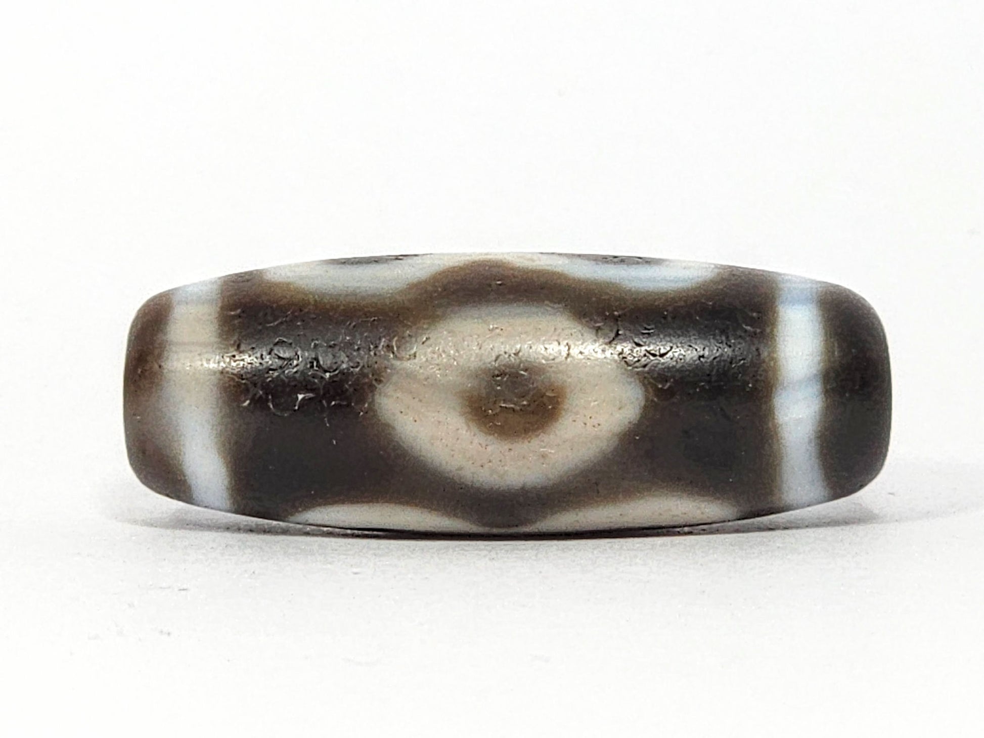 Face B of antique Double Bat Two Eye dzi At-060725-DB2E2, fully resolved concentric-ring eye in broad cream surround on grey-brown agate, dark brown pupil, unretouched photography
