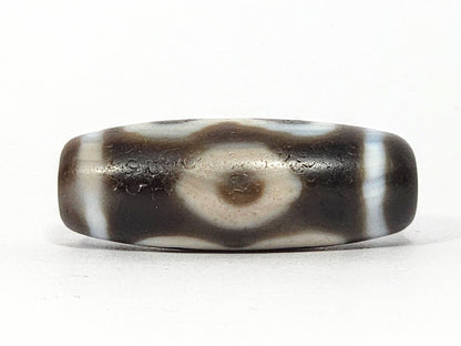 Face B of antique Double Bat Two Eye dzi At-060725-DB2E2, fully resolved concentric-ring eye in broad cream surround on grey-brown agate, dark brown pupil, unretouched photography