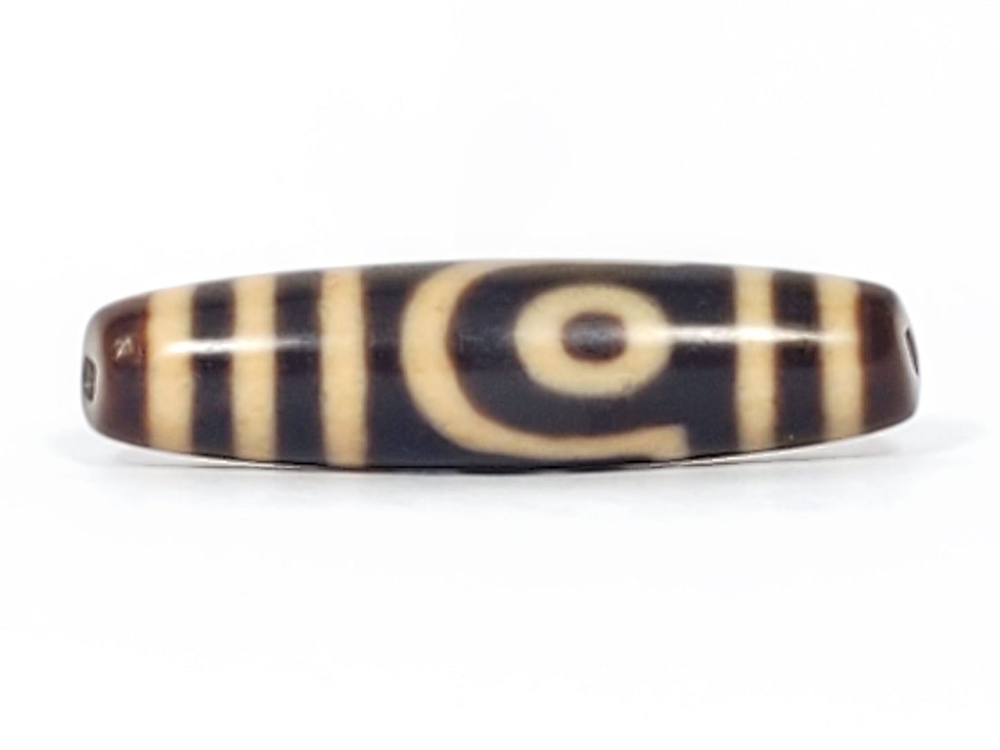 Reverse face of antique two eye dzi bead At-052526-2E2, showing gate or arch motif with rectangular frame and curved lower arch on near-black agate, unretouched