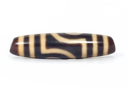 Second face of antique two eye dzi bead At-052526-2E2, compressed open C-ring eye opening left, flanked by vertical stripes, near-black agate with cream patterning