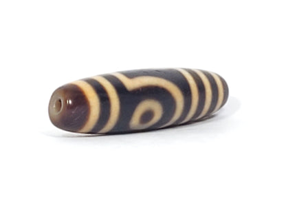 Opposite end cap of antique two eye dzi bead At-052526-2E2, brown tip with drill hole, second open-ring eye face visible, natural agate surface, 47.4mm × 11.8mm