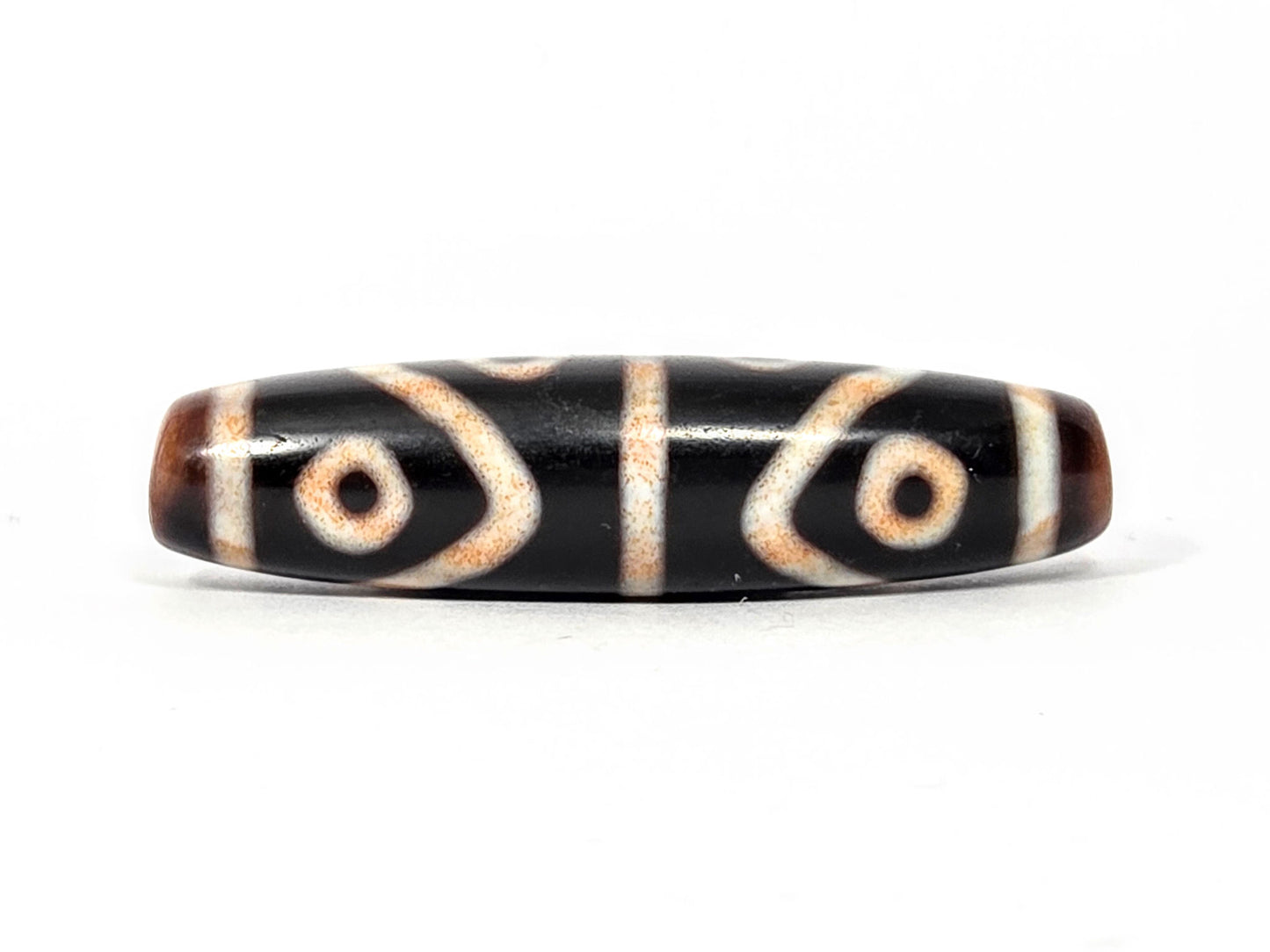 Third face of antique Eight Eye Tiger Tooth Dzi — crisp dual motif, eye circles and tiger tooth visible